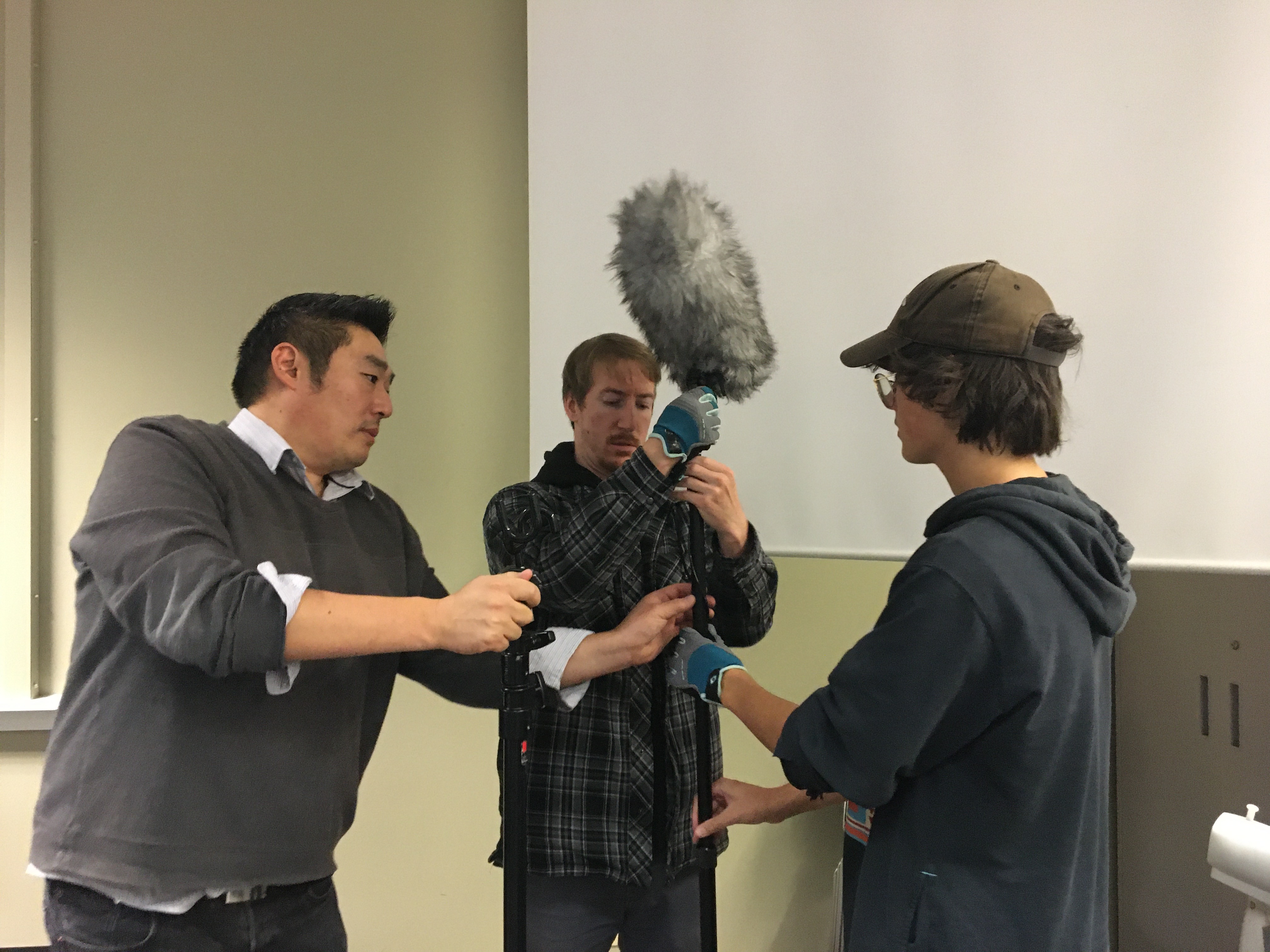 Film instructor and students handling boom mic